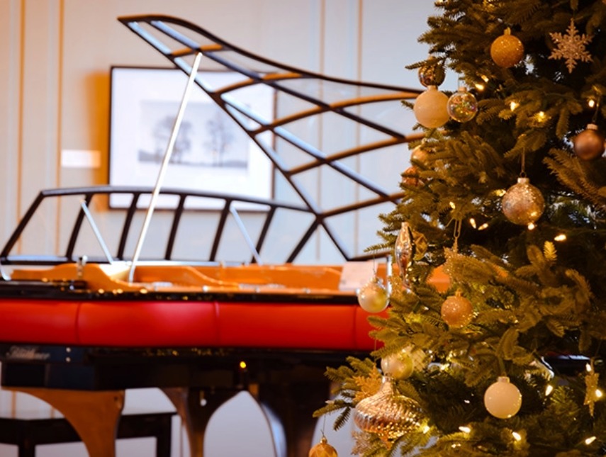 a christmas tree with ornaments and a piano
