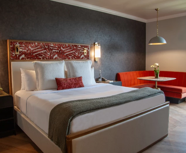 a bed with a red couch and a lamp
