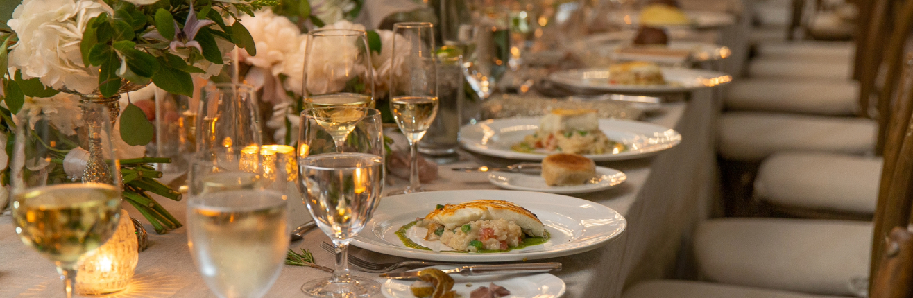 a table with plates of food and glasses of wine