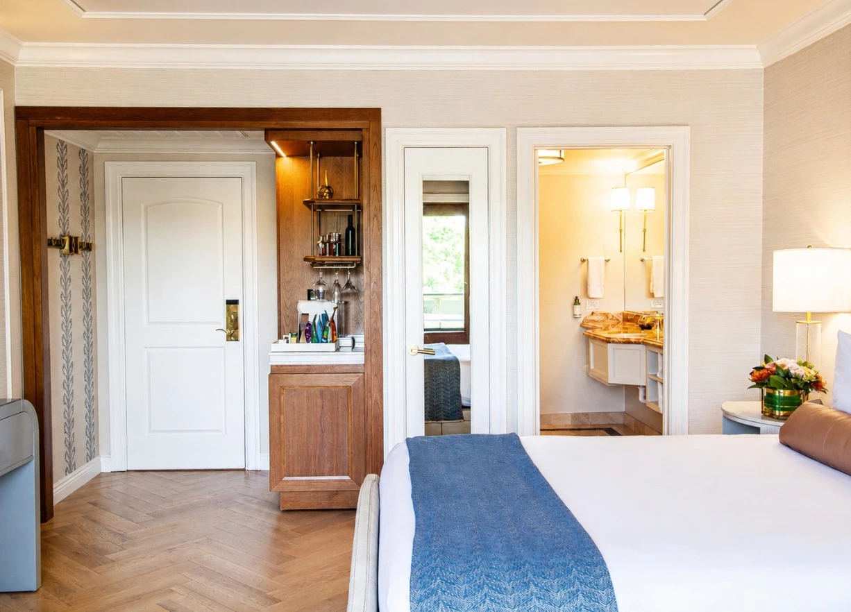A hotel room with a king-sized bed, minibar, and bathroom