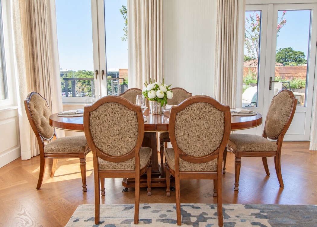 a dining table with chairs in a room with windows