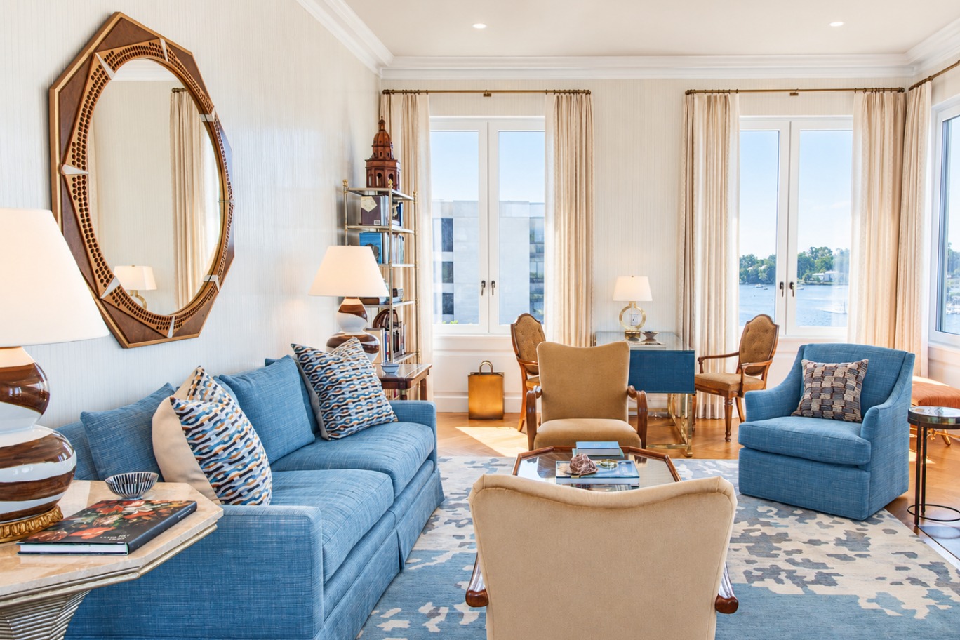 a living room with blue couches and a mirror