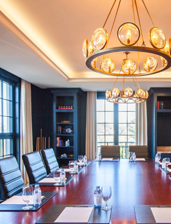 a conference room with a chandelier and chairs