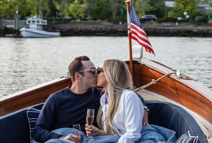 a man and woman kissing on a boat