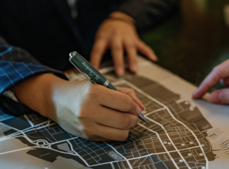 a person holding a pen over a map