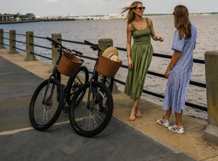 two women standing next to a railing