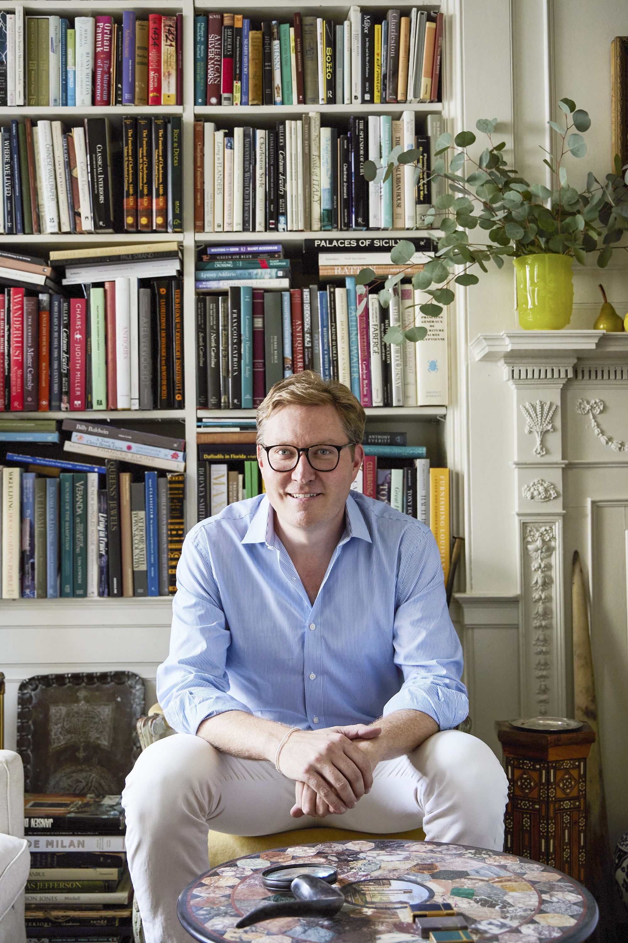 a man sitting in front of a bookcase