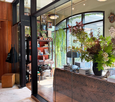 a glass wall with a vase of flowers in front of a store