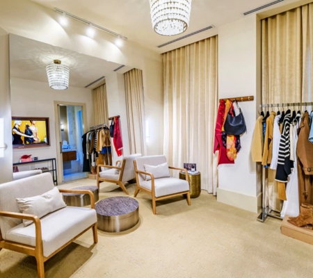 a room with white chairs and a chandelier