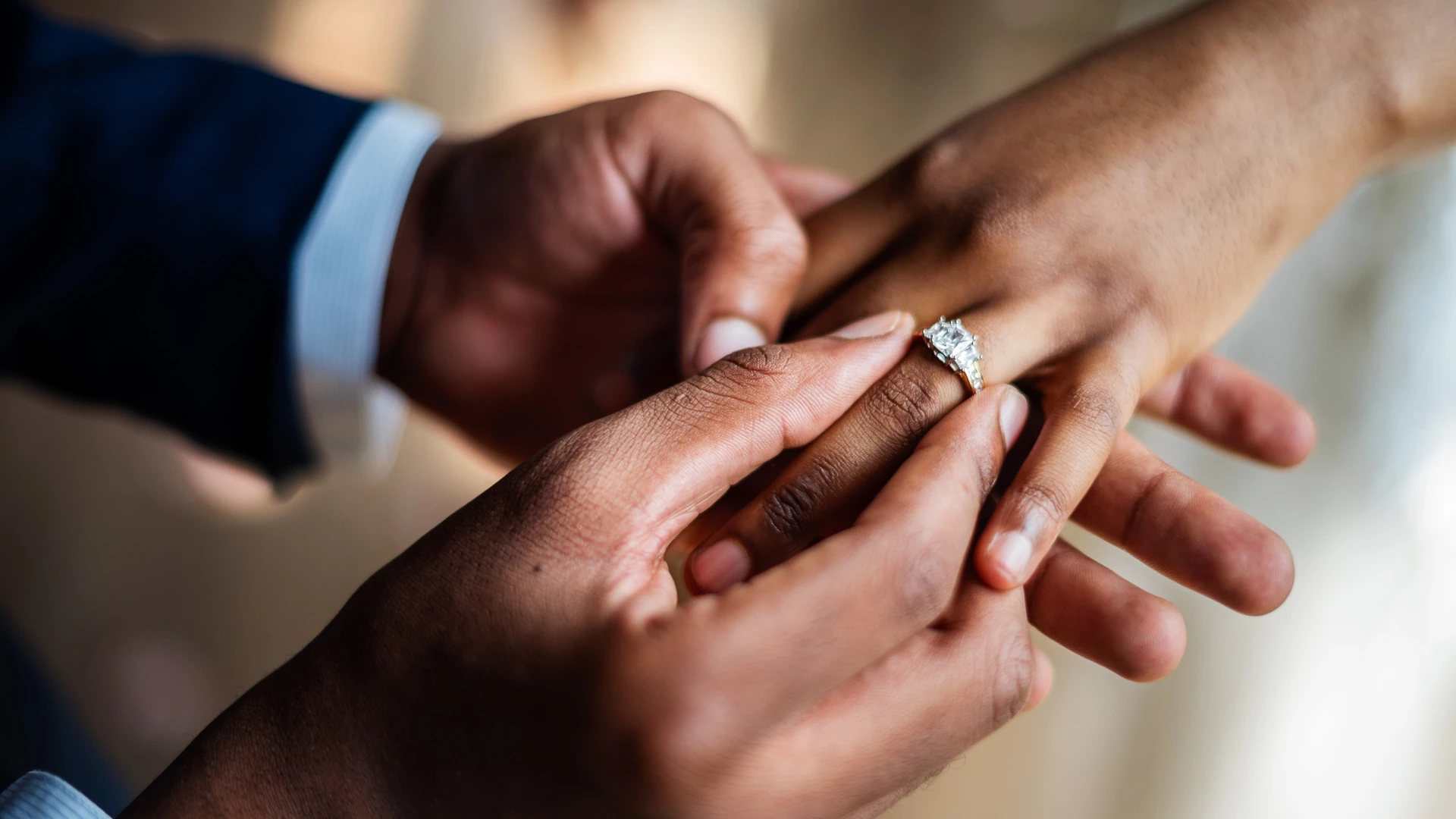 a man putting a ring on a woman's finger