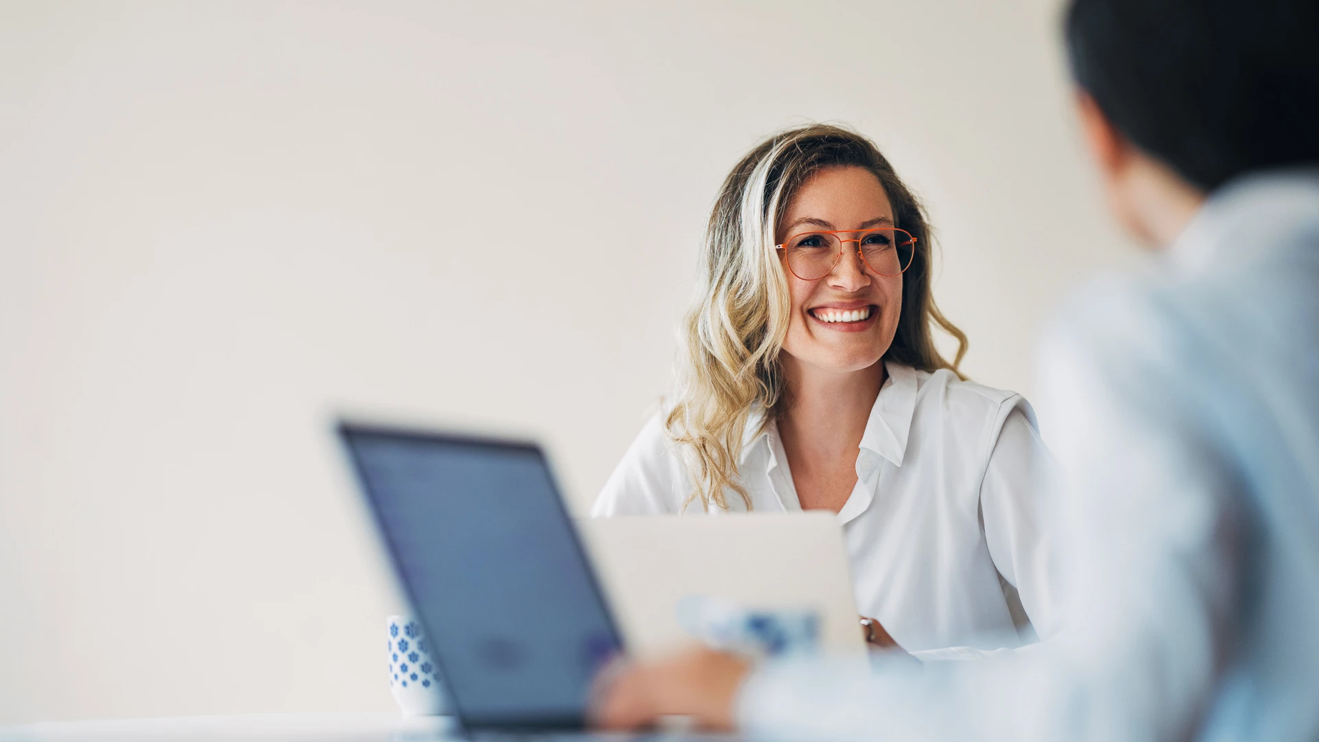 a woman smiling at a laptop