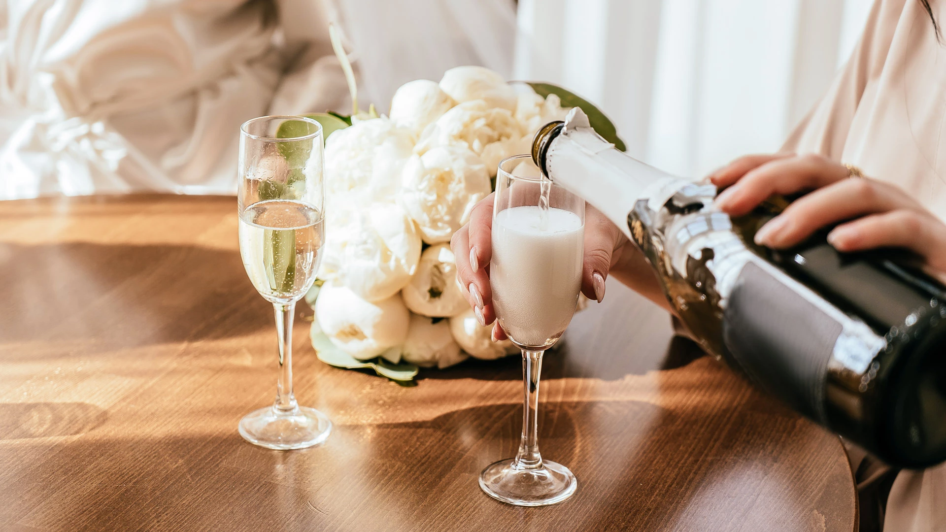 a person pouring champagne into a glass