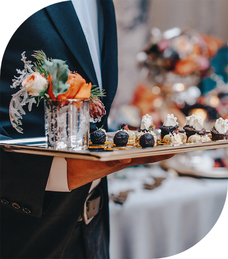 a person holding a tray of desserts
