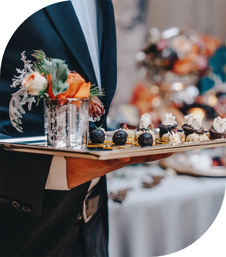 a person holding a tray of desserts