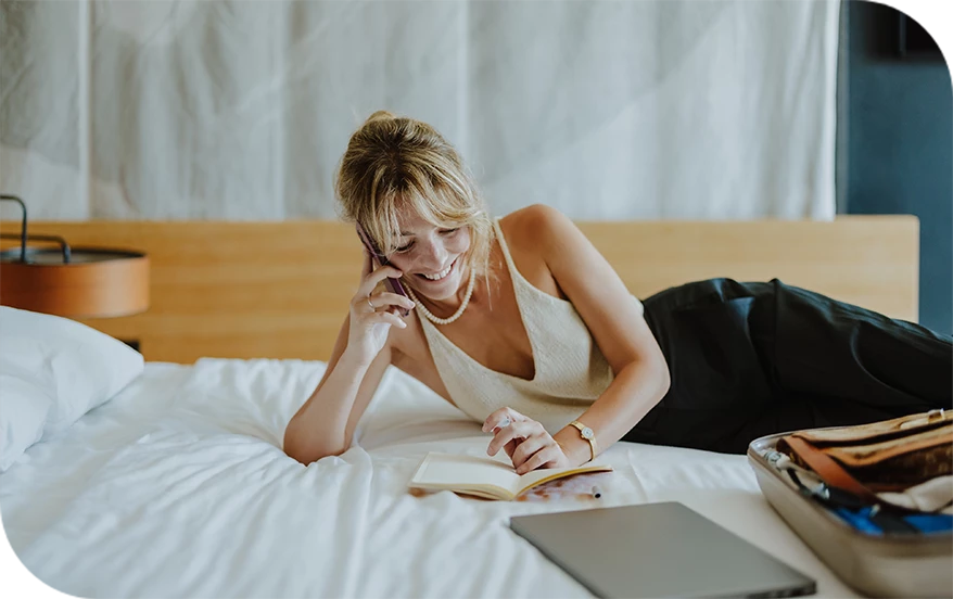 a woman lying on a bed and talking on the phone