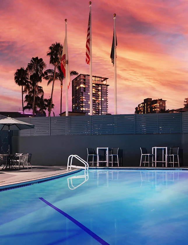 a pool with chairs and flags in the background