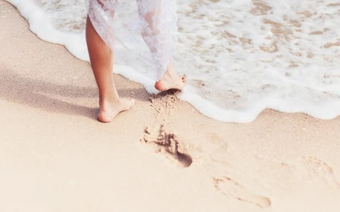 bride dipping her toes in the ocean