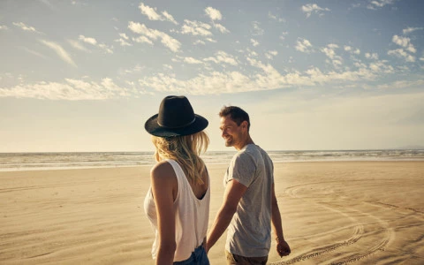 couple holding hands on beach