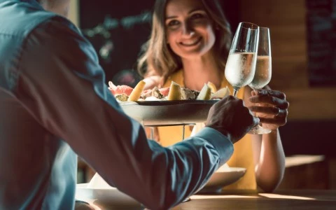 young couple toasting with champagne over dinner