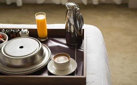 a room service tray with a plate of food, coffee and juice