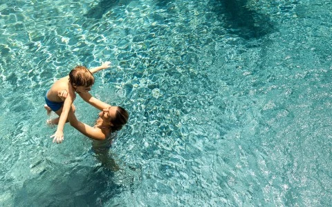 a man and child in a pool 