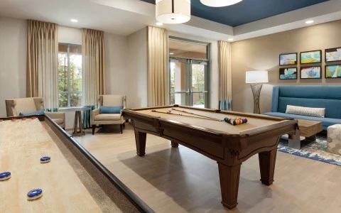 a room with a pool table with chairs