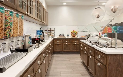 a hotel buffet area with brown cabinets and buffett