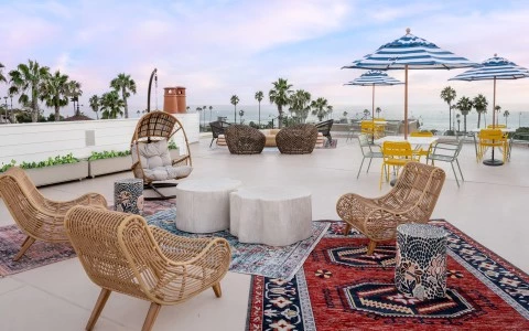 a patio with tables and chairs and umbrellas overlooking the ocean