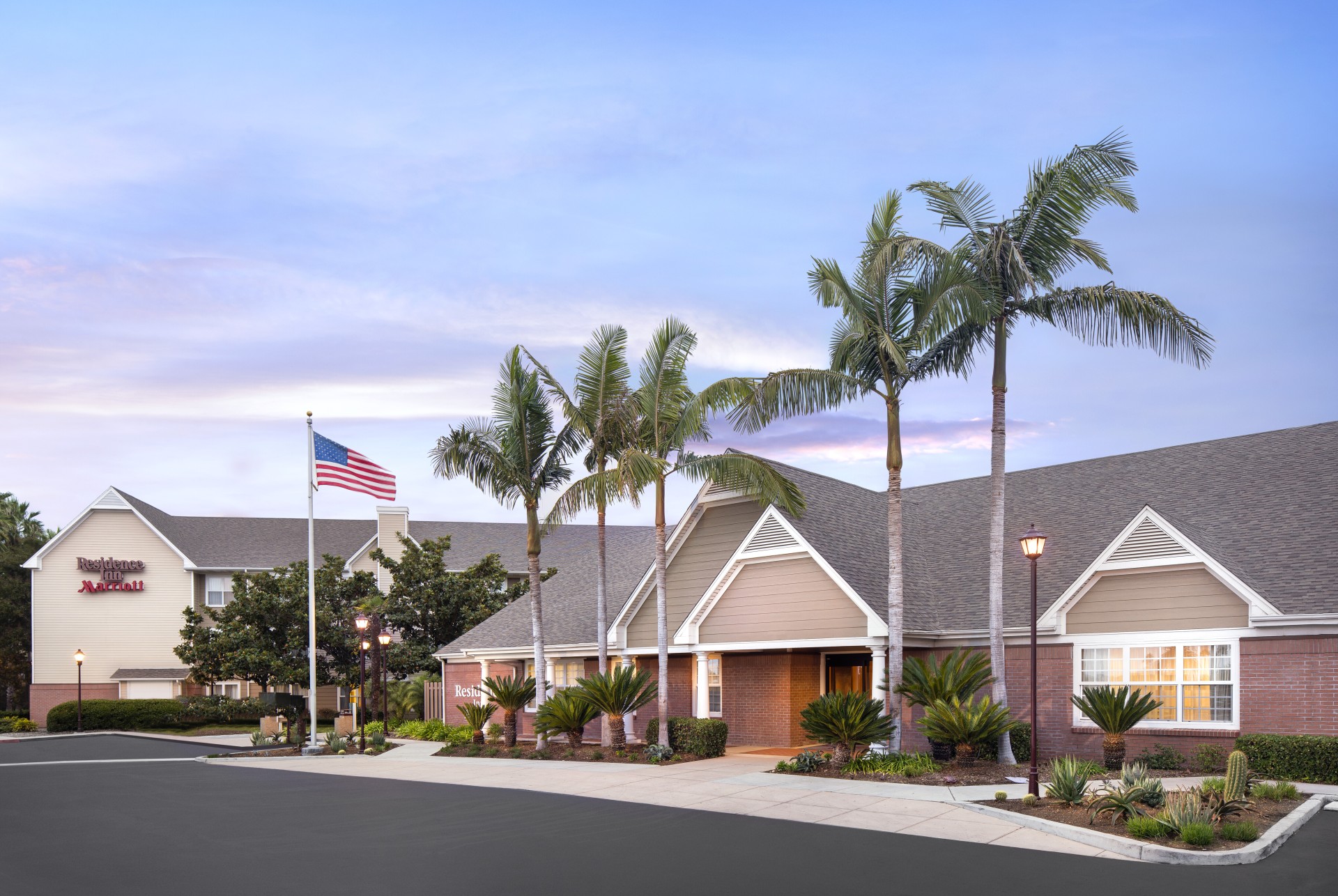 a building with palm trees and a flag