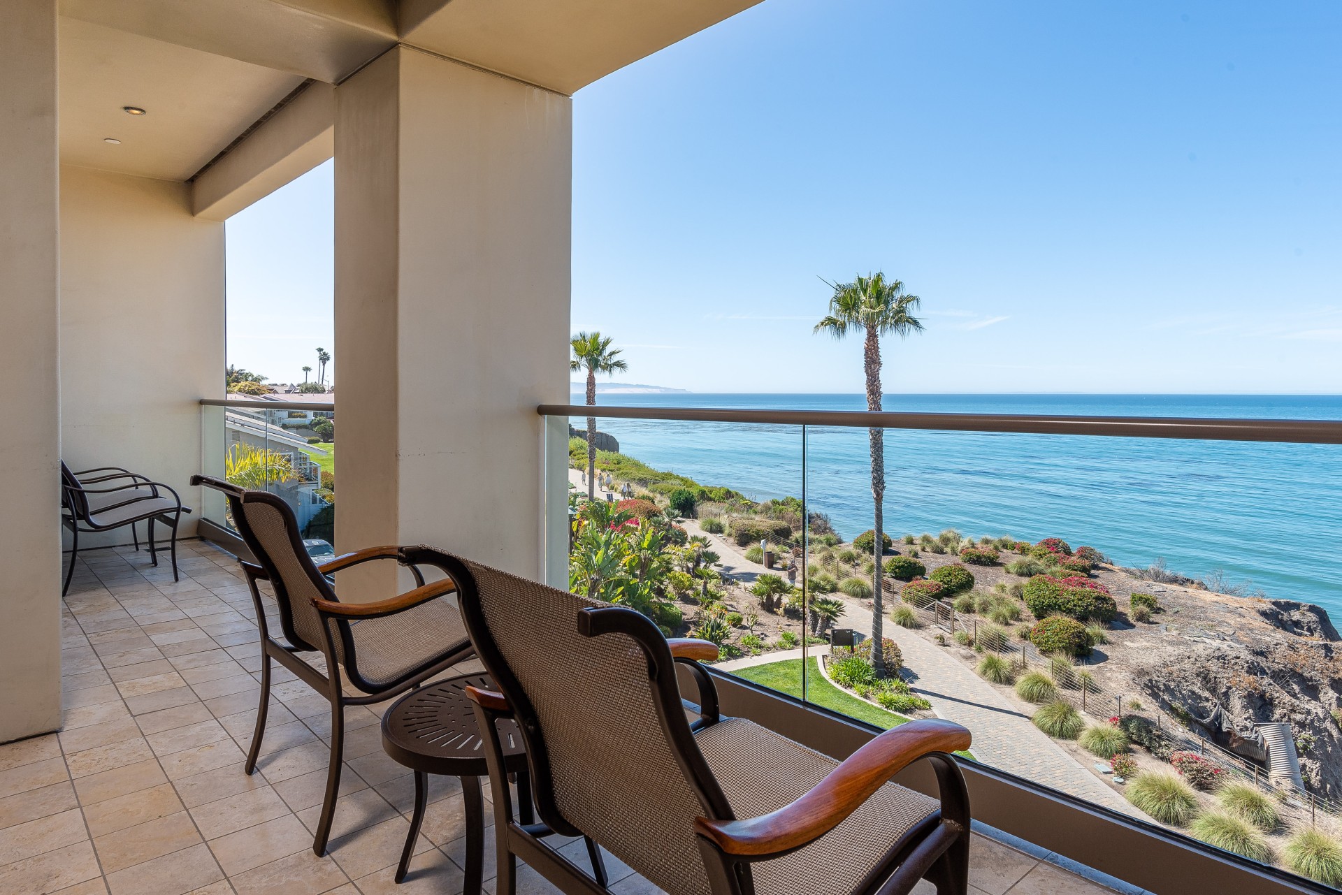 a deck with chairs and a view of the ocean