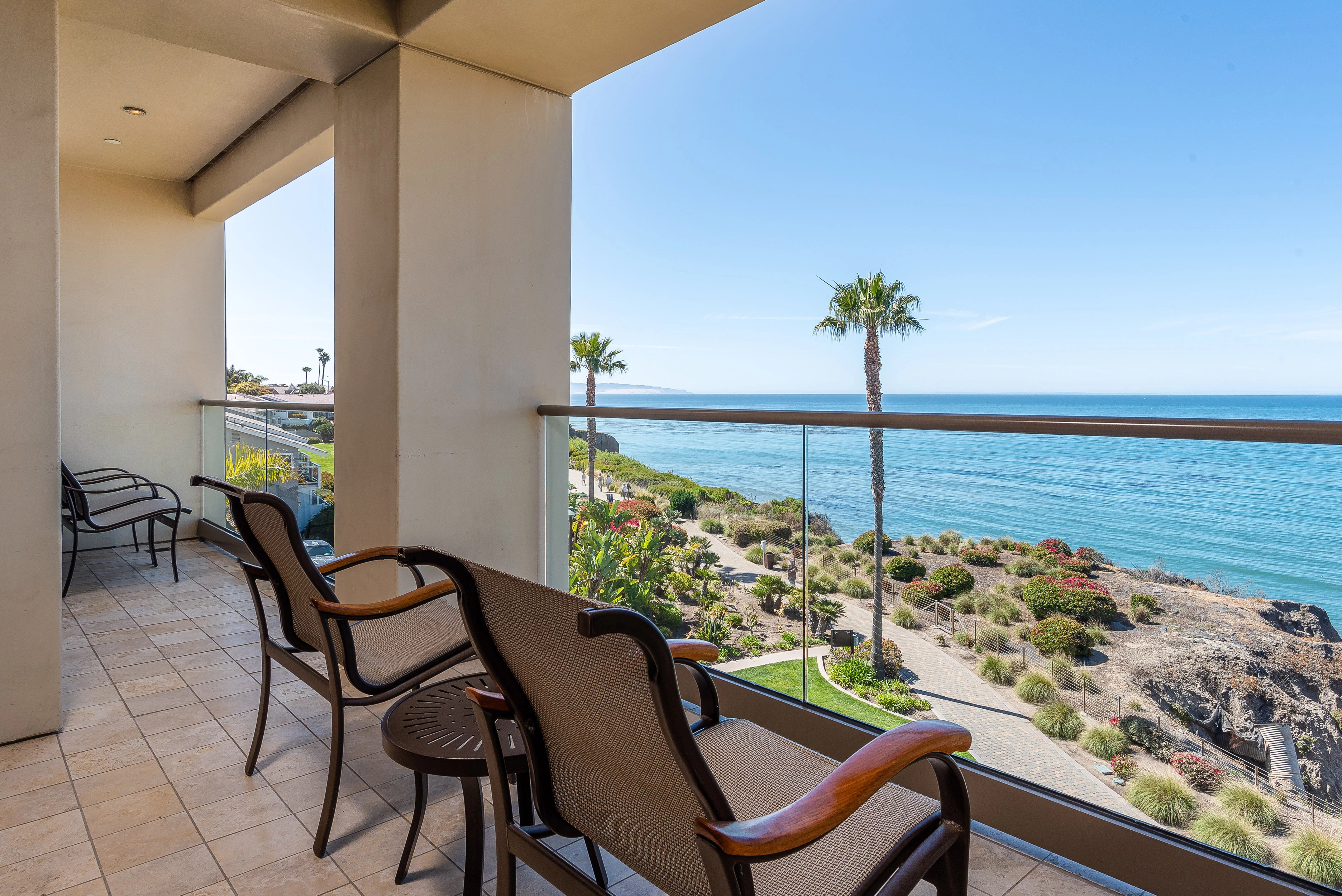 a deck with chairs and a view of the ocean