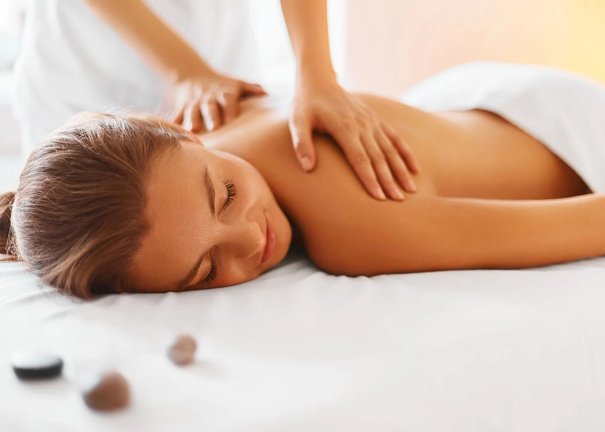 a woman lying down on a bed with her eyes closed