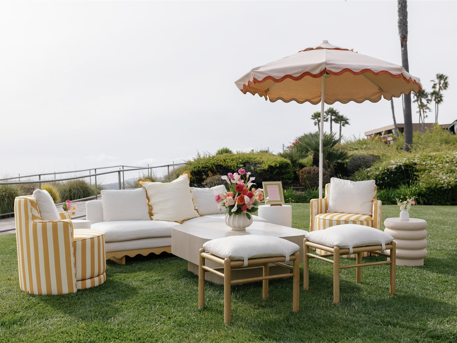 Oceanfront lounge setup with Italian coastal décor, yellow and white accents, and relaxed wedding celebration vibes on the lawn at Dolphin Bay Resort & Spa.