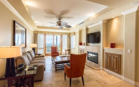 living room area with long beige sofa and two red chairs