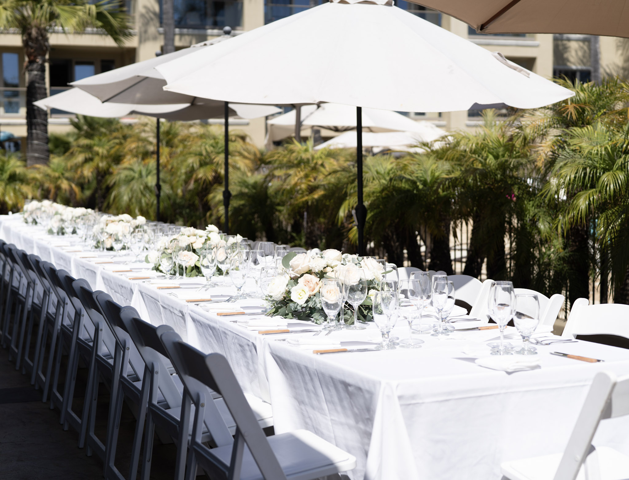 Poolside Patio at Dolphin Bay Resort & Spa in Pismo Beach — heated reception space with partial ocean views, palm trees, and flexible seating for intimate weddings or smaller celebrations.