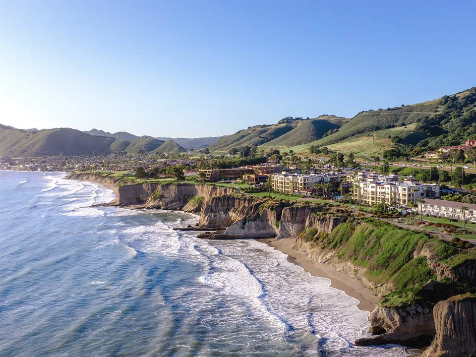 a beach with buildings and waves on the side