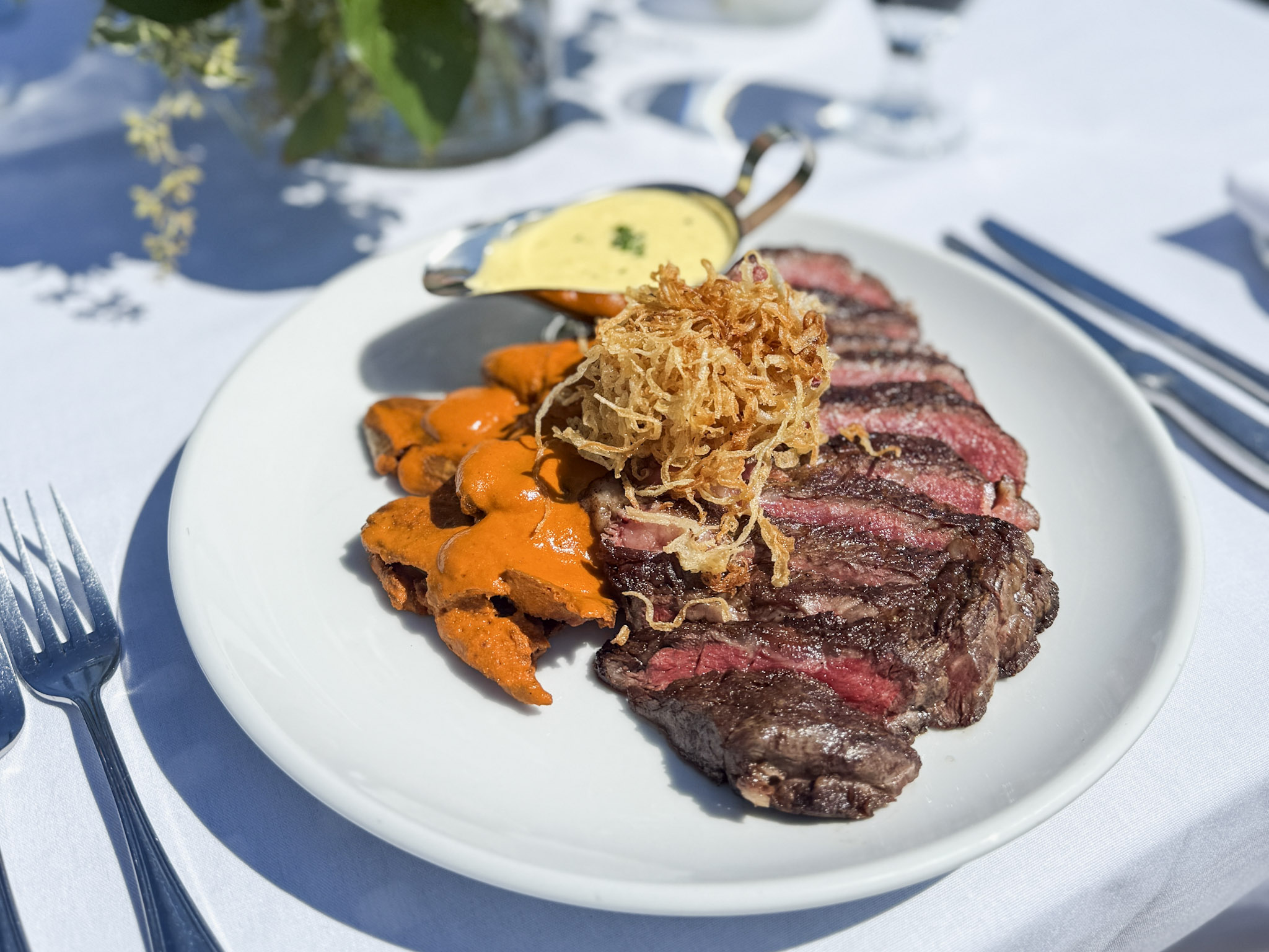 16oz Demkota Ranch Prime Ribeye with crispy fingerling potatoes, béarnaise sauce, and house steak sauce from Lido Restaurant & Lounge at Dolphin Bay Resort & Spa, served on a private oceanfront dining table at The Point in Pismo Beach.