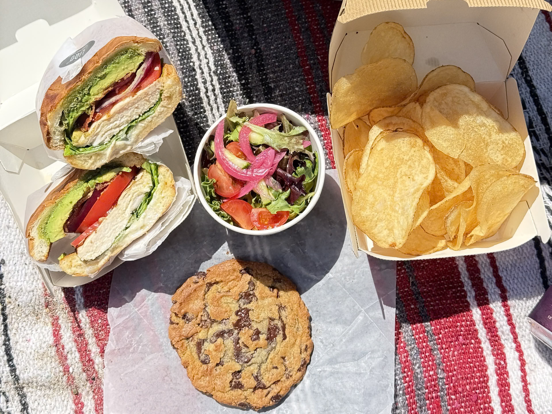 a sandwich and potato chips on a blanket