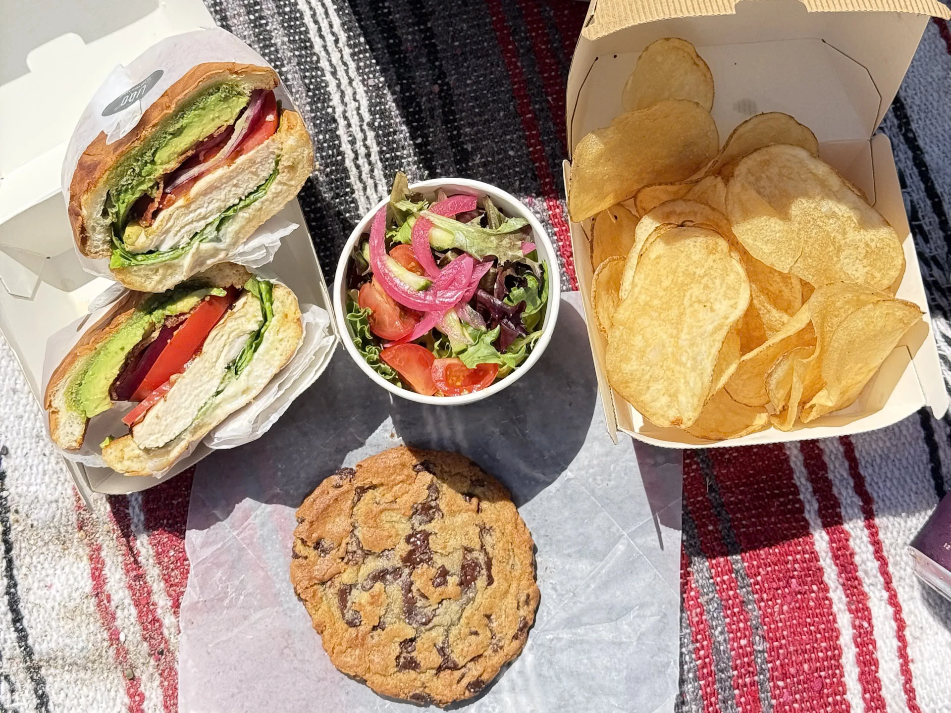 a sandwich and potato chips on a blanket