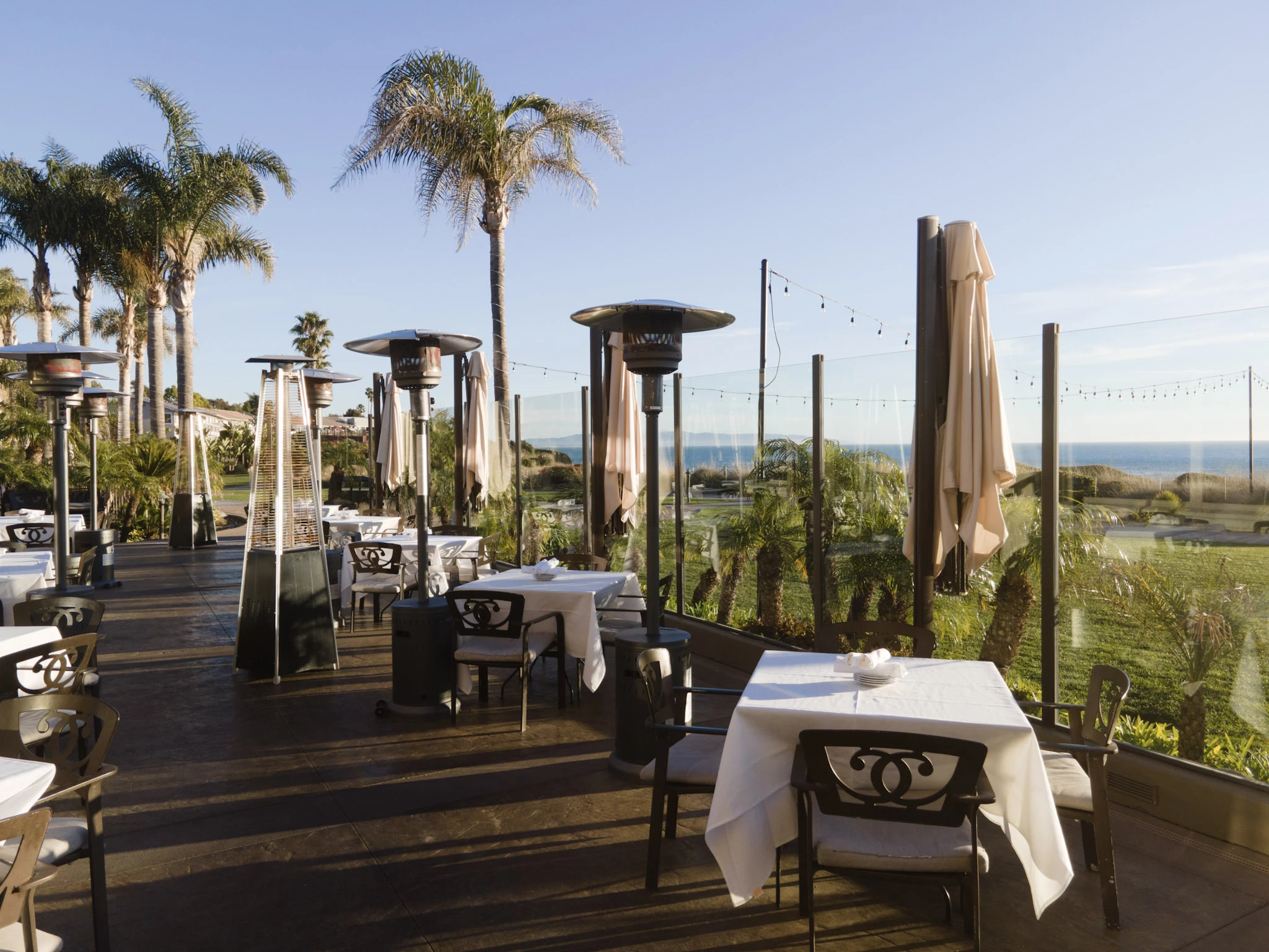 a patio with tables and chairs and umbrellas
