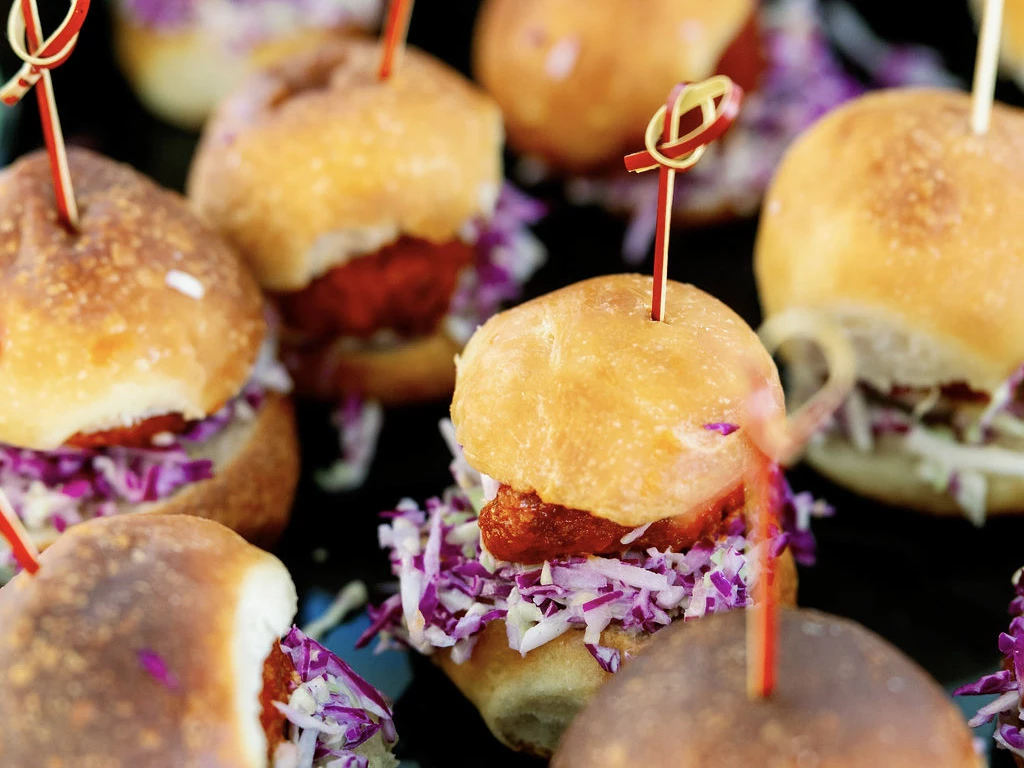 a group of small sandwiches with meatballs and cabbage
