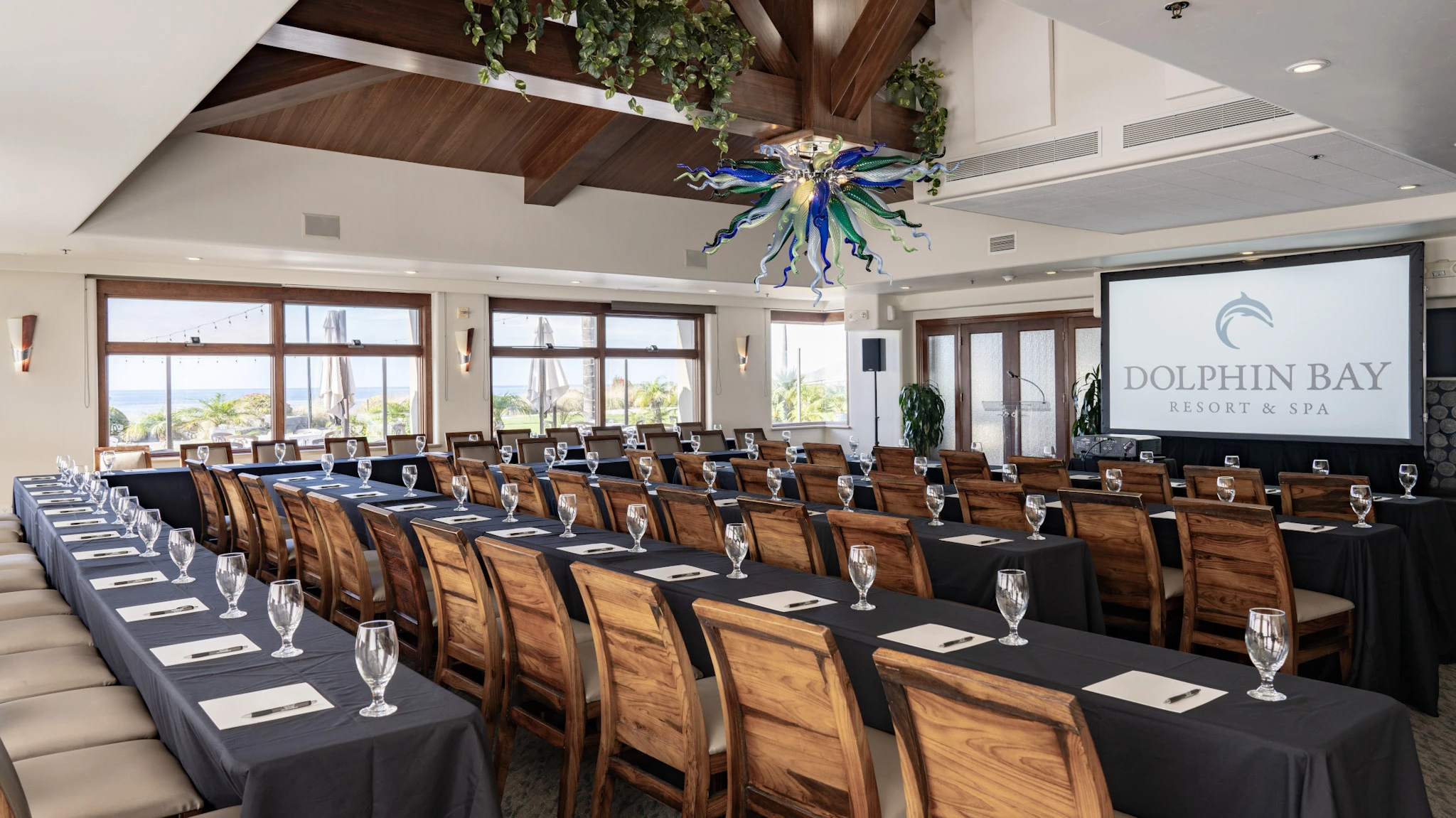 Lido Dining Room & Lounge at Dolphin Bay Resort & Spa in Pismo Beach set in a classroom-style layout with rows of tables facing a presentation screen — ideal for corporate meetings, trainings, and conferences with ocean views.