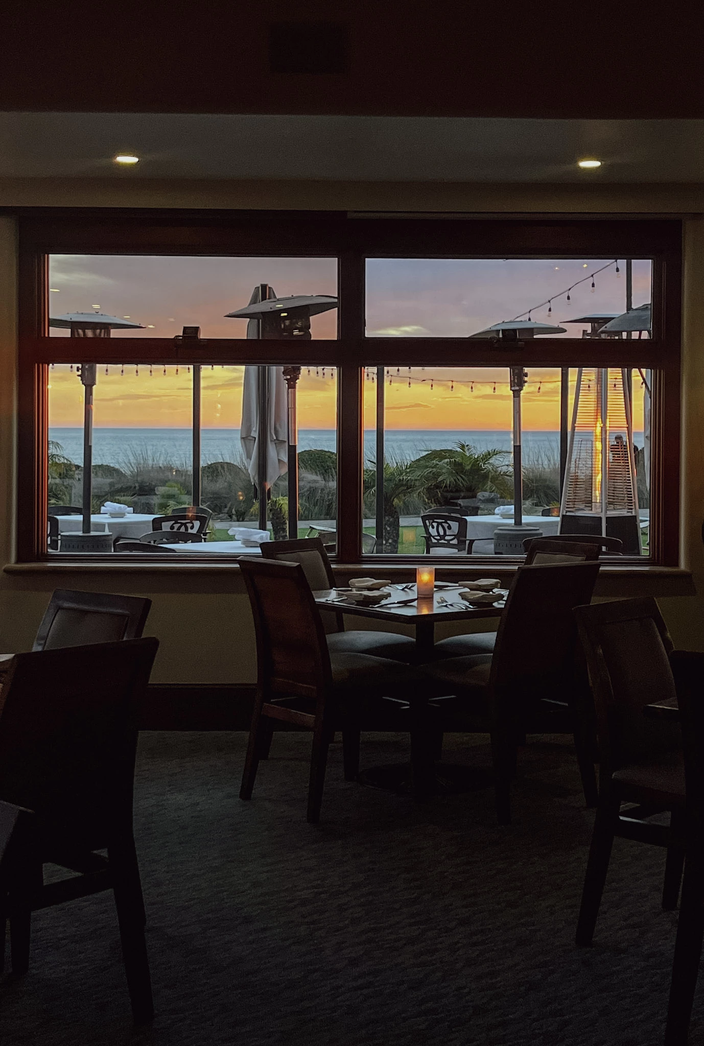 a room with a table and chairs and a view of the ocean