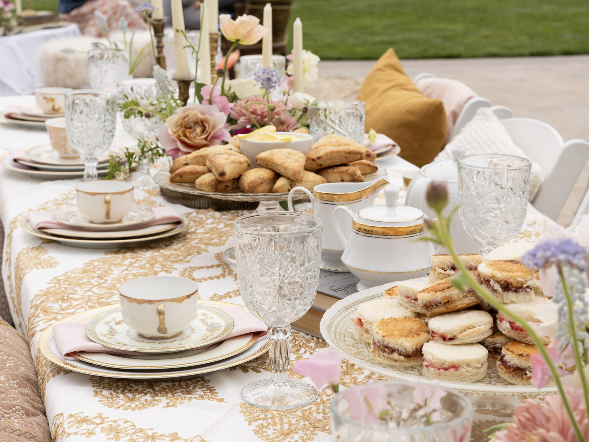 Elegant tea party setup at Dolphin Bay Resort & Spa in Pismo Beach featuring floral décor, teapots, tea cups, and finger foods — a charming setting for birthdays, baby showers, or gatherings of all ages.