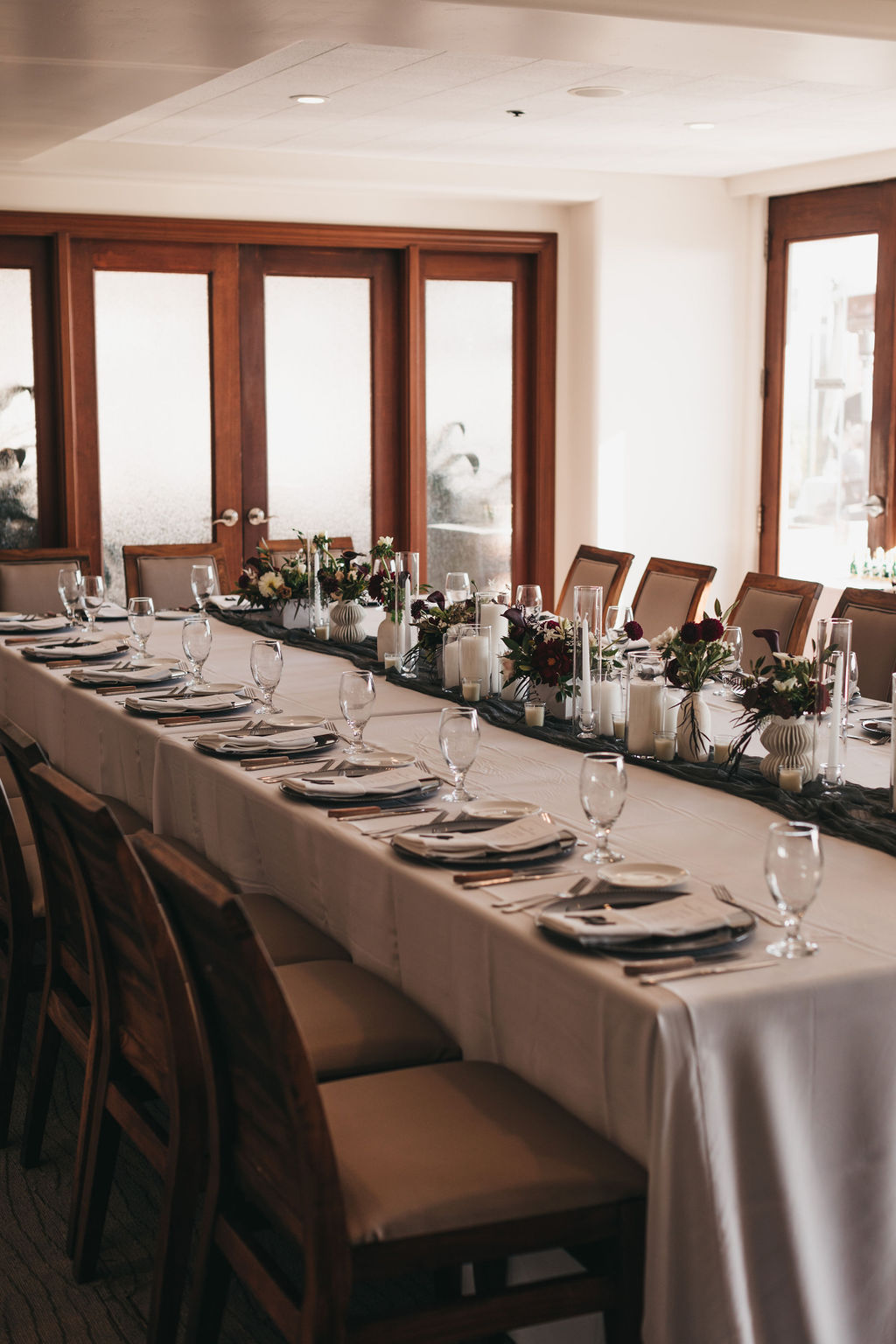 Coastal Room at Dolphin Bay Resort & Spa in Pismo Beach — intimate indoor wedding reception with a long wooden table, warm wood accents, and cozy coastal ambiance, perfect for smaller celebrations.