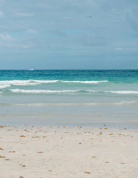 a beach with waves and a blue sky