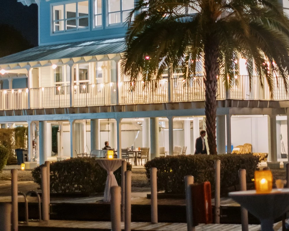 a building with a palm tree and a man walking in front of it