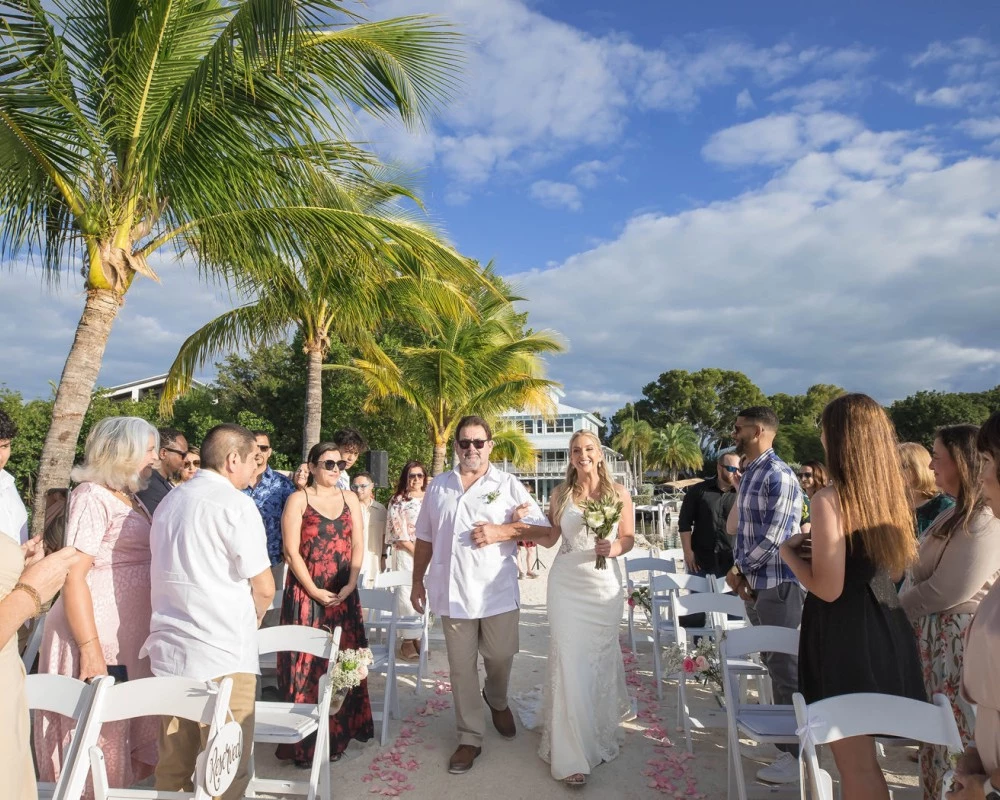 wife holding man's arm walking in a wedding walkway