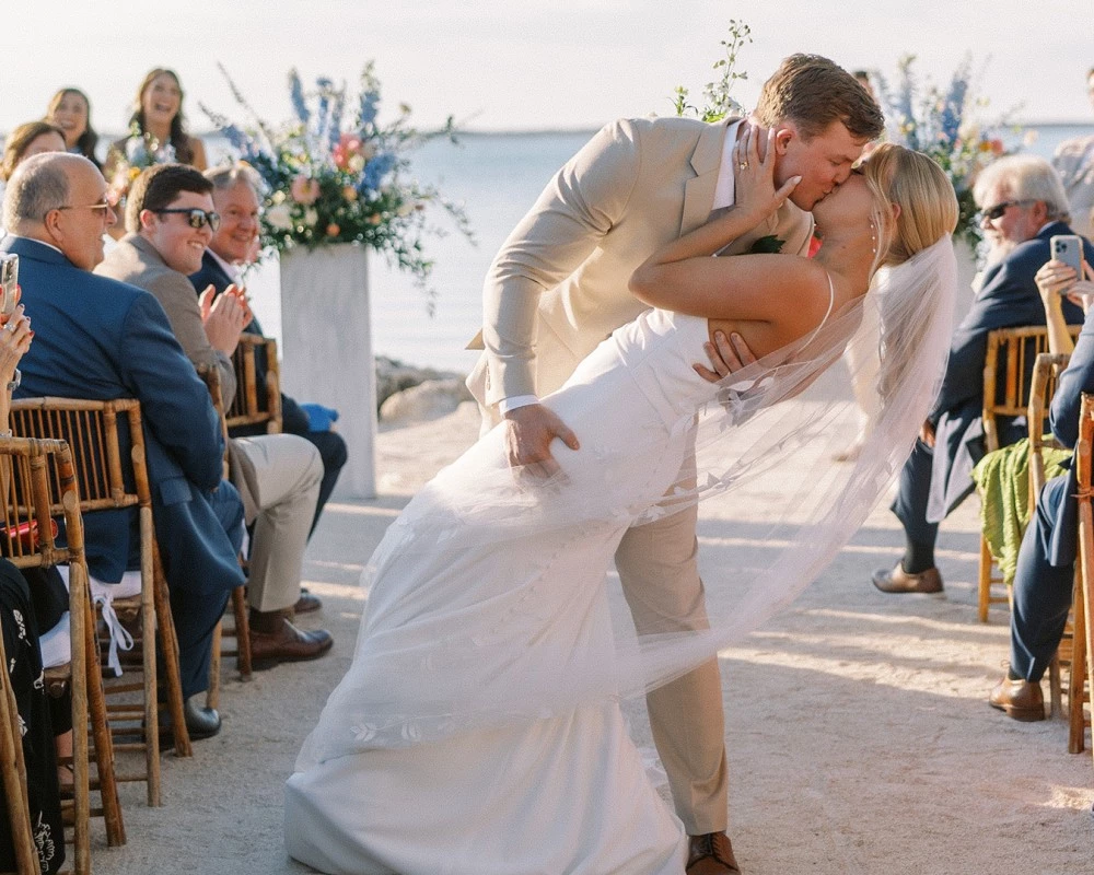 a man and woman kissing at a wedding