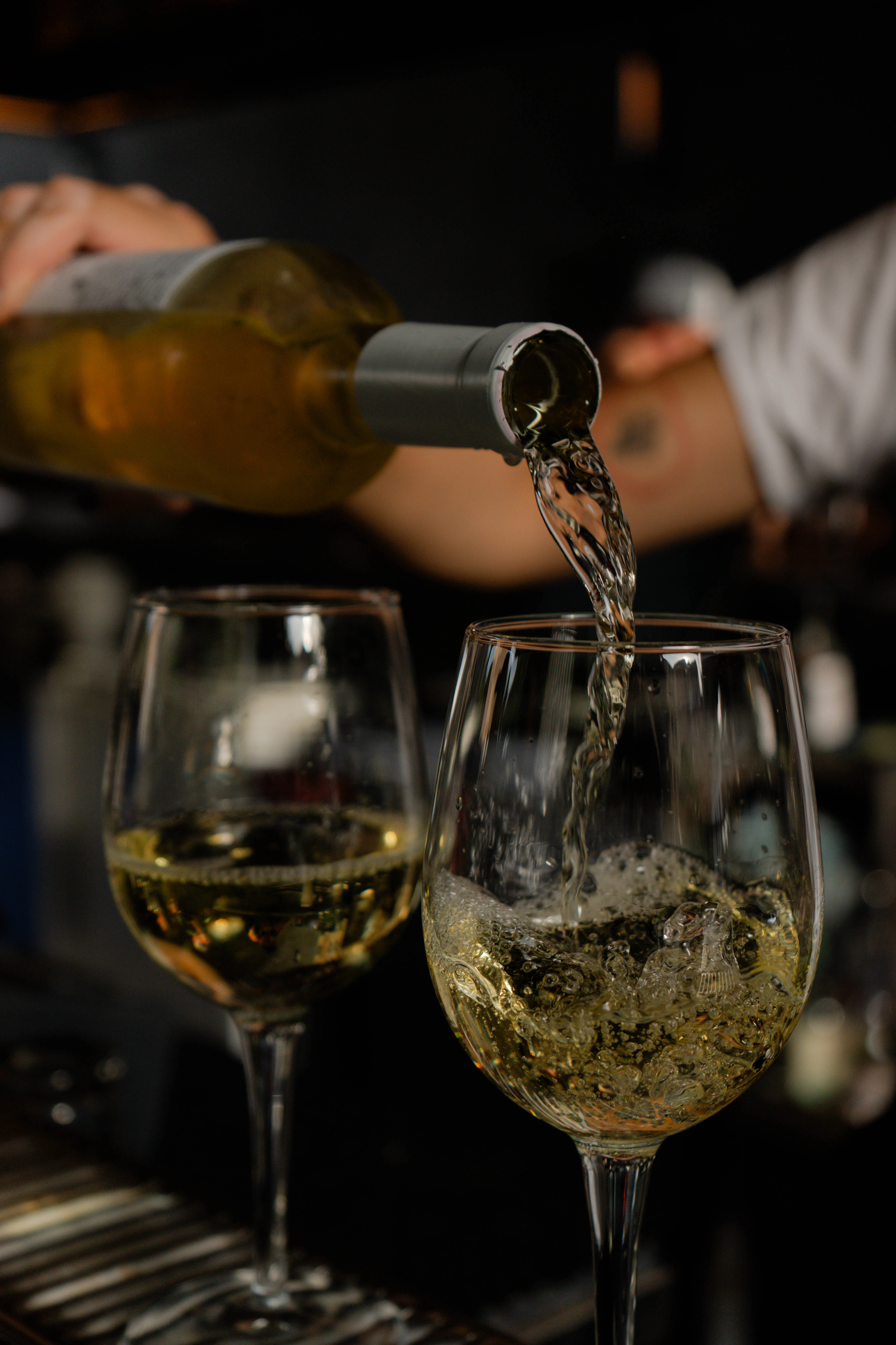 a person pouring wine into a glass